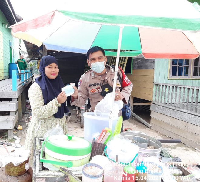 Bagikan Masker, Bhabinkamtibmas Desa Muara Bumban Dorong Warga Disiplin Terapkan Prokes