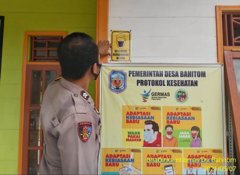 Bersama Babinsa, Bhabinkamtibmas Desa Muara Bumban Sosialisasikan Prokes Covid-19