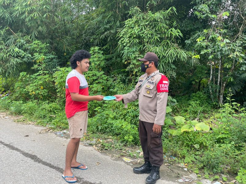 Bripka Abdul Haris Berikan Imbauan Prokes kepada Warga dengan Berikan Masker