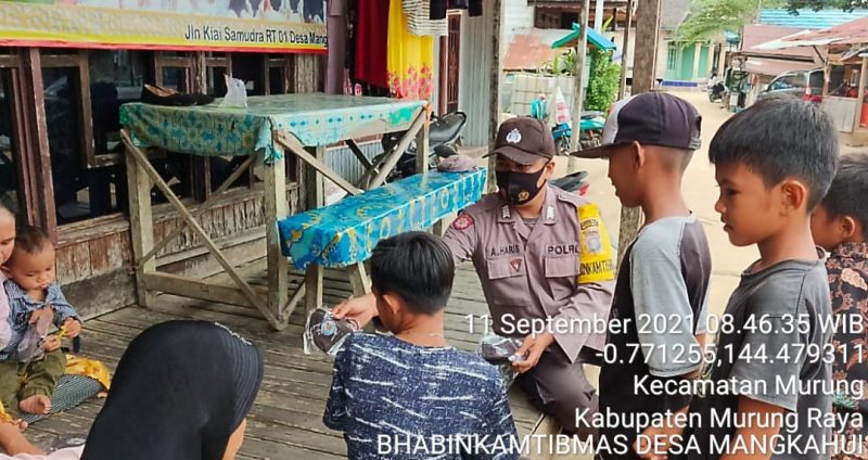 Bripka Kriswanto Sosialisasikan Prokes Sembari Semprotkan Hand sanitizer