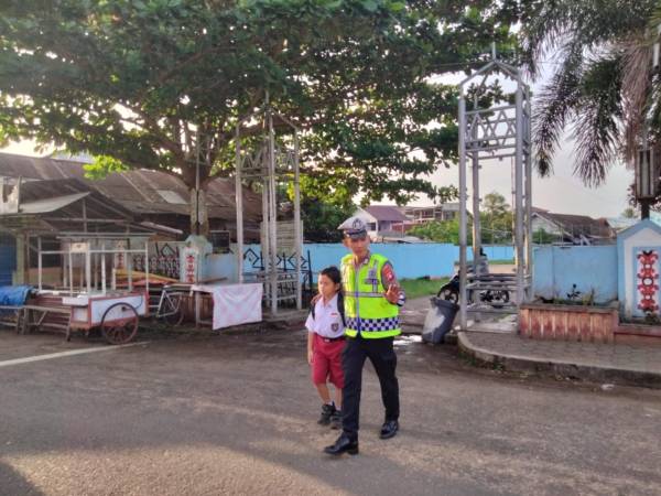 Anggota Satlantas Polres Seruyan Bantu Anak Sekolah Menyebrang Jalan
