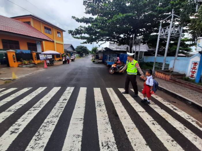Satlantas Polres Seruyan Rutin  Bantu Anak Sekolah Menyeberang Jalan